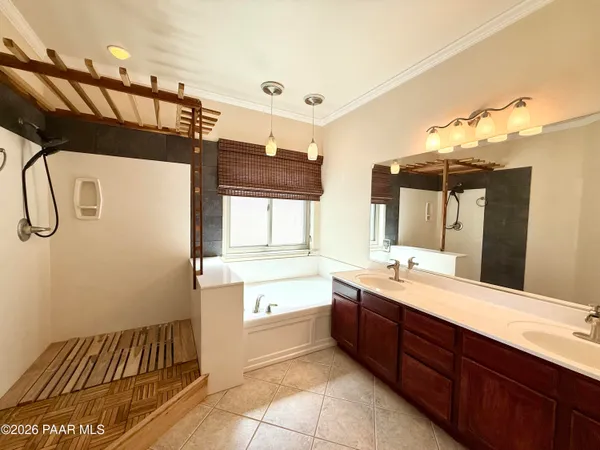 a spacious bathroom with a double vanity sink a mirror and a bathtub