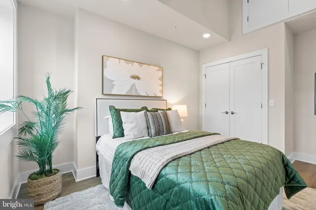 a bed sitting in a bedroom next to a window with potted plant