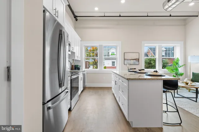 a kitchen with stainless steel appliances a refrigerator and a stove top oven