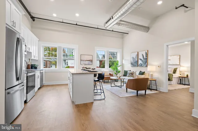 a kitchen with a refrigerator and wooden floor