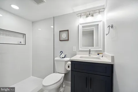 a bathroom with a toilet a sink and mirror