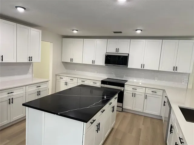 a view of kitchen with wooden cabinet