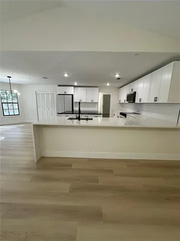 a kitchen with stainless steel appliances granite countertop a sink a stove and a refrigerator