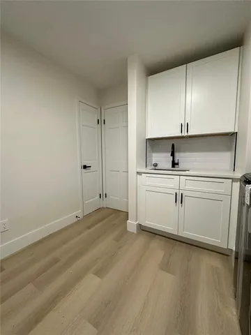 an empty room with windows and ceiling fan