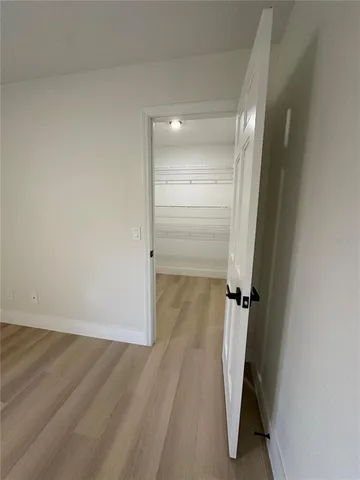 an empty room with windows and ceiling fan