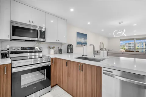 a kitchen with stainless steel appliances granite countertop a sink and a stove top oven with white countertops