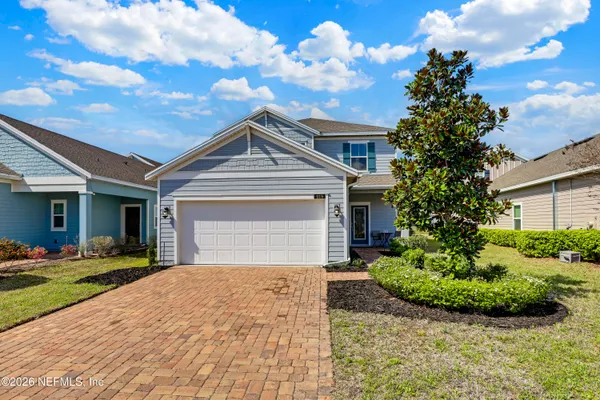 a front view of a house with a yard and potted plants