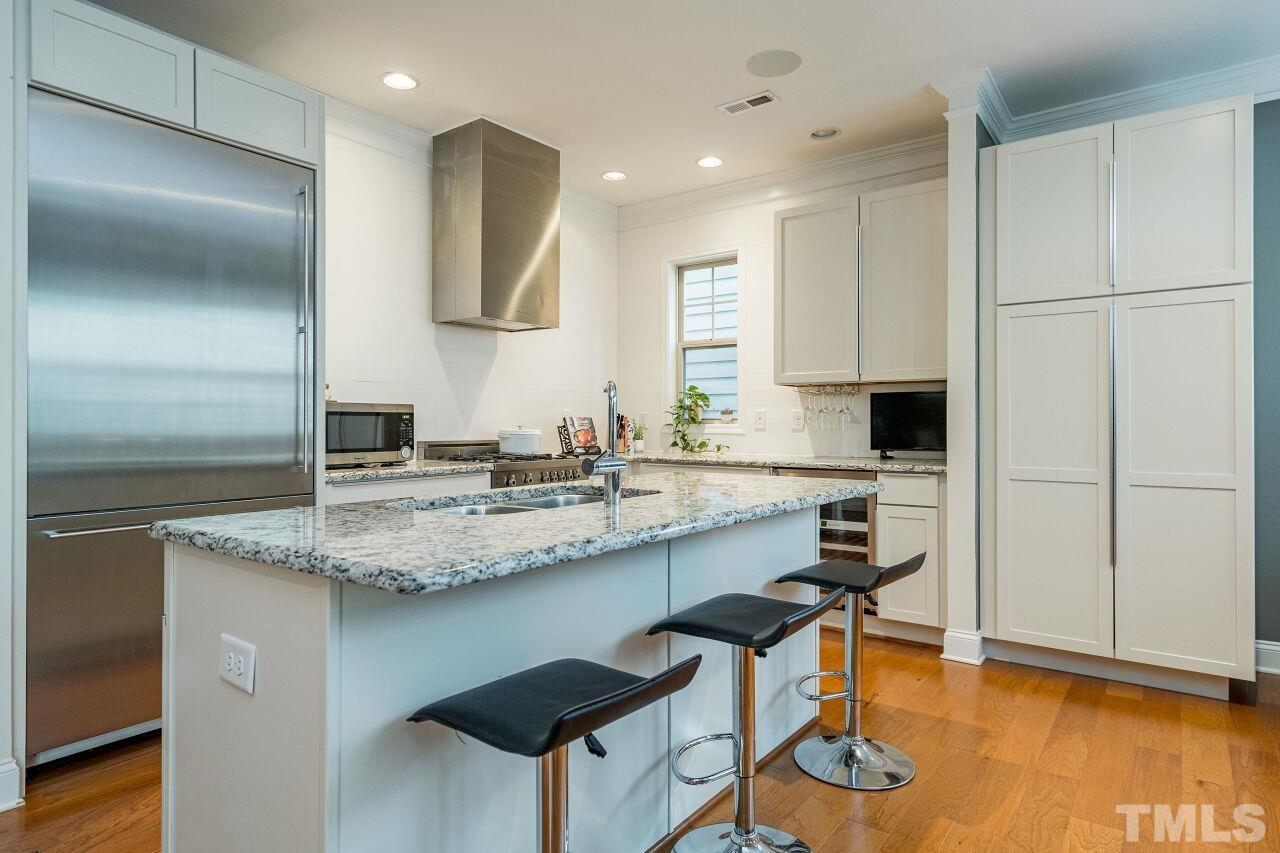 1517 Fullerton Place Raleigh, NC 27607 - Photo 12 of 30 True chef's kitchen w/upgraded white cabinets, granite counters, Gaggenau and Bertazzoni appliances, wine fridge, oversized island. Sleek in design and perfect for use.