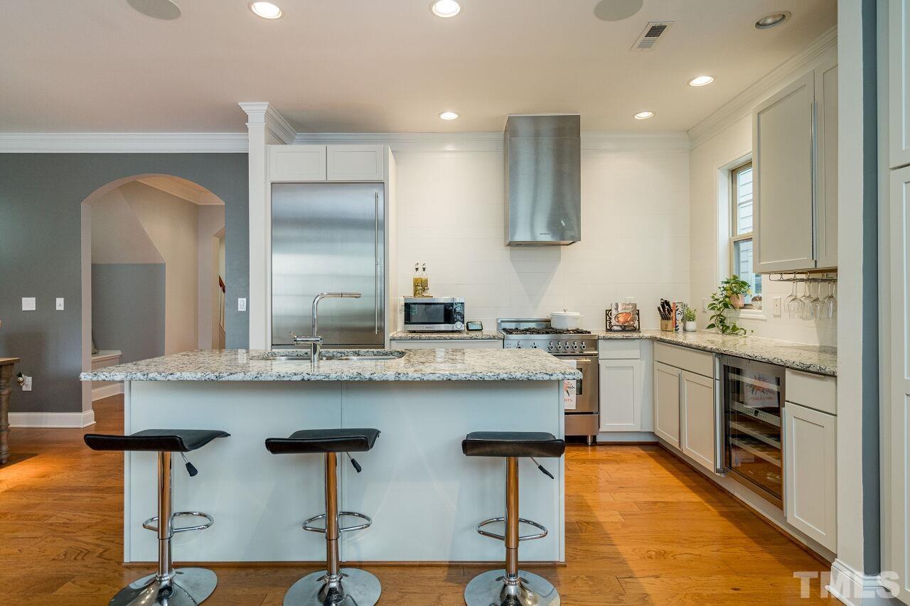 1517 Fullerton Place Raleigh, NC 27607 - Photo 13 of 30 True chef's kitchen w/upgraded white cabinets, granite counters, Gaggenau and Bertazzoni appliances, wine fridge, oversized island. Sleek in design and perfect for use.