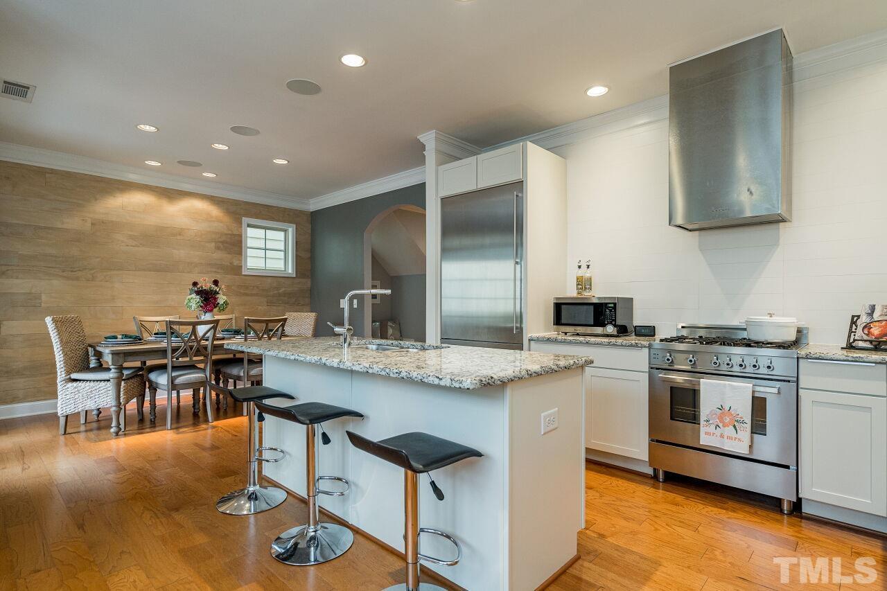 1517 Fullerton Place Raleigh, NC 27607 - Photo 14 of 30 True chef's kitchen w/upgraded white cabinets, granite counters, Gaggenau and Bertazzoni appliances, wine fridge, oversized island. Sleek in design and perfect for use.