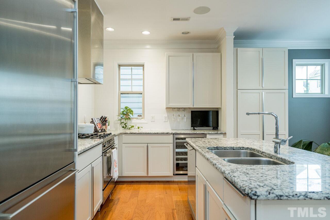 1517 Fullerton Place Raleigh, NC 27607 - Photo 15 of 30 True chef's kitchen w/upgraded white cabinets, granite counters, Gaggenau and Bertazzoni appliances, wine fridge, oversized island. Sleek in design and perfect for use.