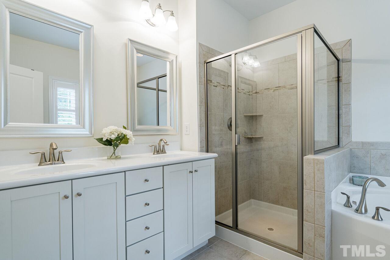 1517 Fullerton Place Raleigh, NC 27607 - Photo 21 of 30 Glamorous owner's suite bathroom with dual sinks, shaker style white cabinets, tile throughout, garden tub & glass enclosed shower.