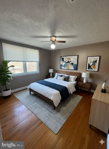 an empty room with wooden floor chandelier fan and windows