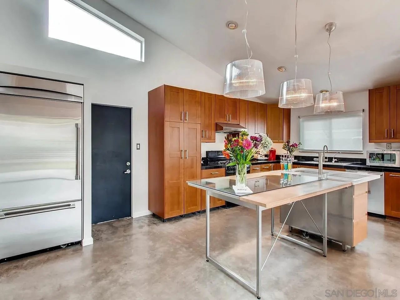 6428 Shirehall Drive San Diego, CA 92111 - Photo 10 of 15 a kitchen with stainless steel appliances kitchen island granite countertop a refrigerator and microwave