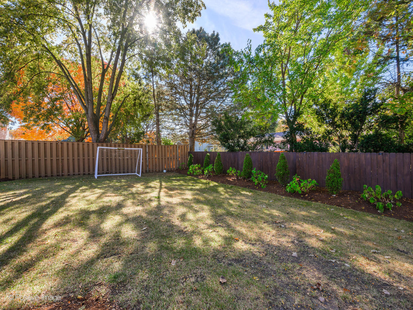 1026 Elmdale Road Glenview, IL 60025 - Photo 35 of 38 a view of a backyard with large trees and wooden fence