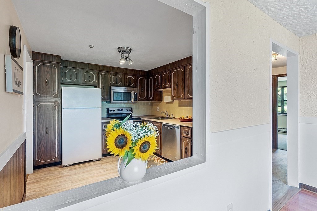 61 Spencer Road, Unit 30I Boxborough, MA 01719 - Photo 3 of 28 a kitchen with stainless steel appliances granite countertop a refrigerator and a stove top oven