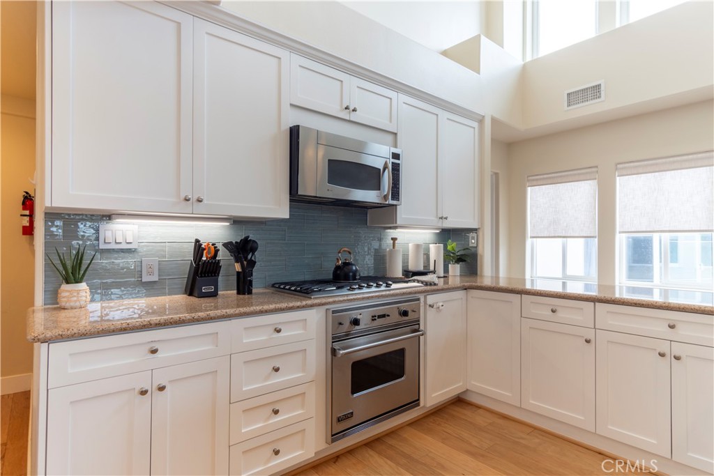 62 62nd Place Long Beach, CA 90803 - Photo 17 of 55 a kitchen with white cabinets and white appliances