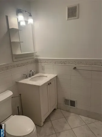 a bathroom with a sink mirror vanity and toilet
