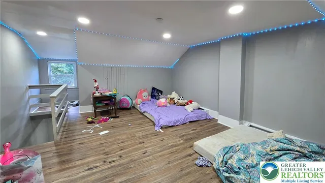 a bedroom with a bed and a wooden floor