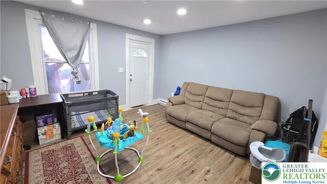 a kitchen with stainless steel appliances granite countertop a refrigerator a sink dishwasher a dining table and chairs with wooden floor