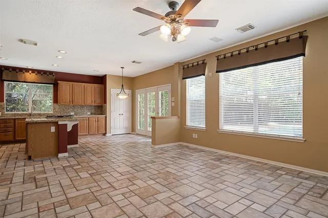 a large kitchen with kitchen island granite countertop a large window cabinets and stainless steel appliances