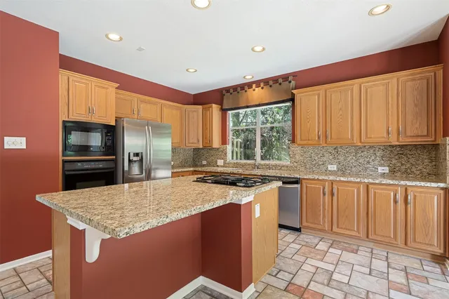 a kitchen with stainless steel appliances granite countertop a stove a sink dishwasher and a refrigerator