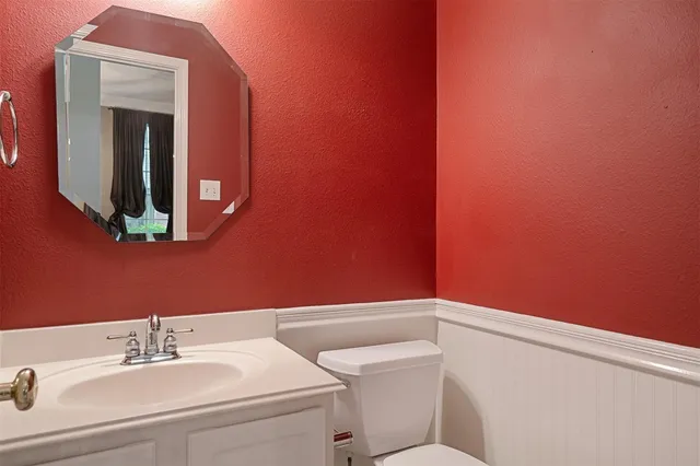 a bathroom with a toilet a sink and mirror