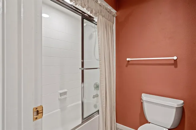a bathroom with a toilet and shower