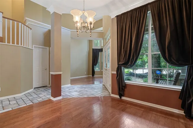 a view of a bedroom with wooden floor and a window