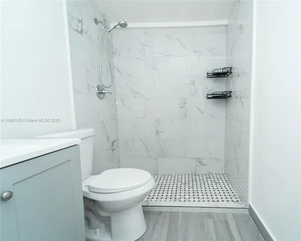a bathroom with a toilet a sink and shower