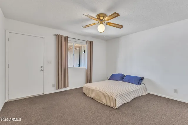 a bedroom with a bed and a chandelier fan