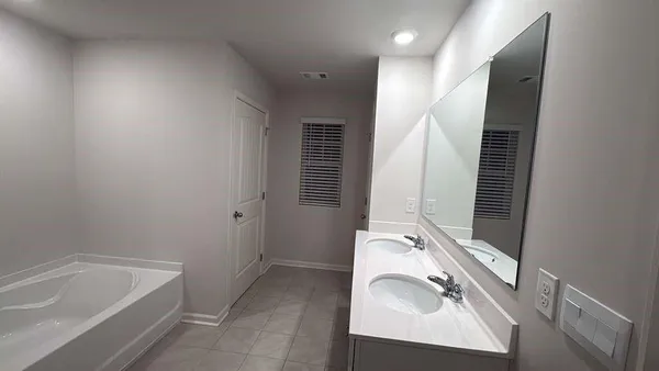 a bathroom with a tub sink and mirror