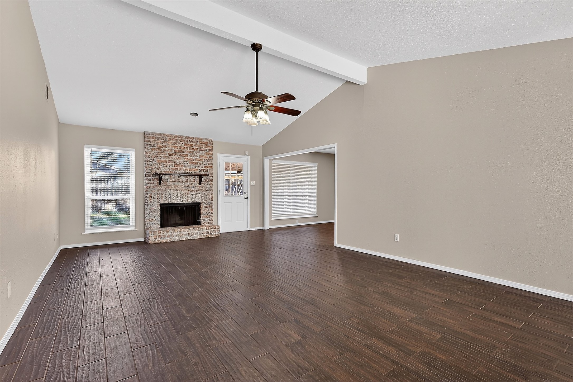 3027 Windmill Street Sugar Land, TX 77479 - Photo 4 of 36 a view of an empty room with wooden floor a fireplace and a window