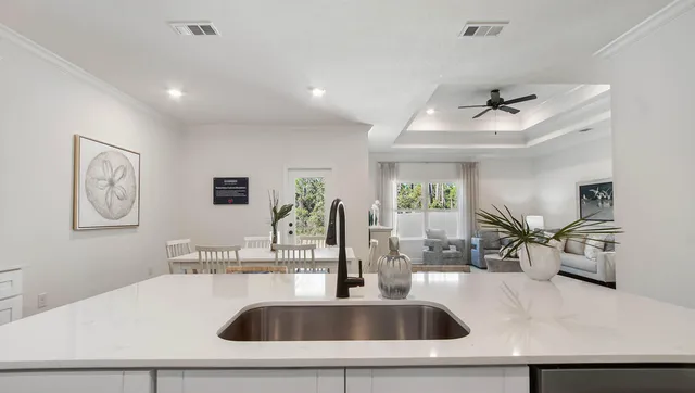 a kitchen with stainless steel appliances a white table chairs and a refrigerator
