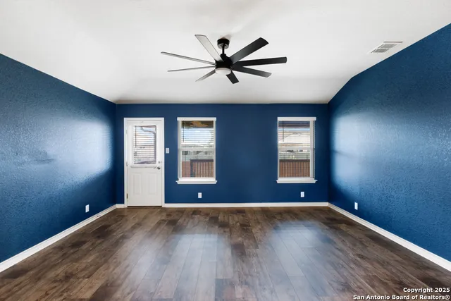 a view of a livingroom with a furniture ceiling fan and wooden floor