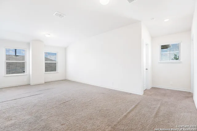 an empty room with a window and a fan