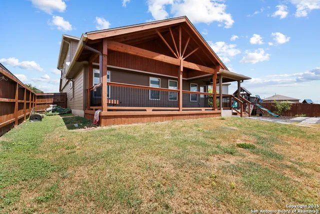 a view of an house with backyard and a slide