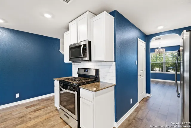 a kitchen with granite countertop a stove and a sink