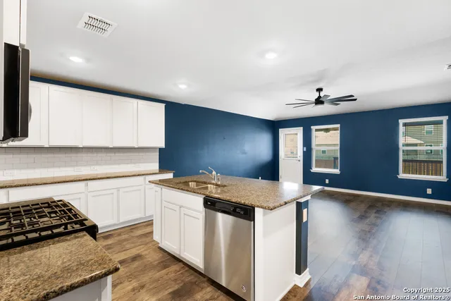 a kitchen with stainless steel appliances granite countertop a sink stove microwave and oven