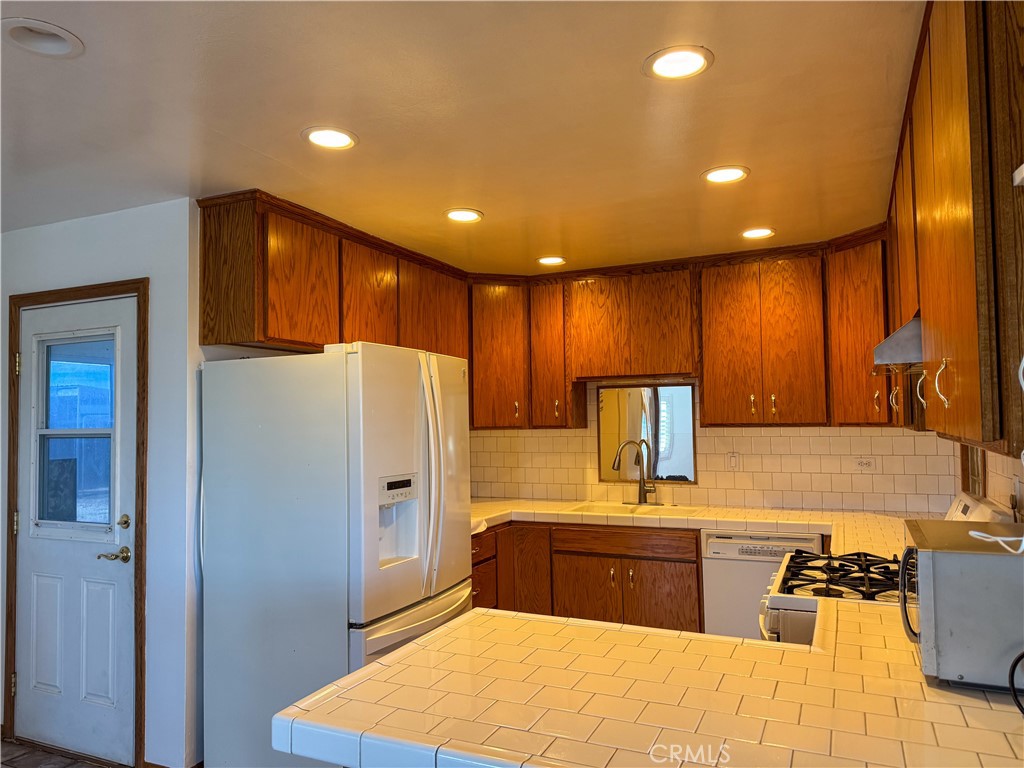 44665 95th Street East Lancaster, CA 93535 - Photo 6 of 34 a kitchen with stainless steel appliances a refrigerator sink and cabinets