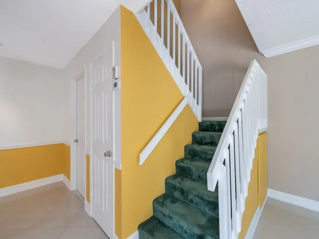 a living room with furniture a flat screen tv and a large window