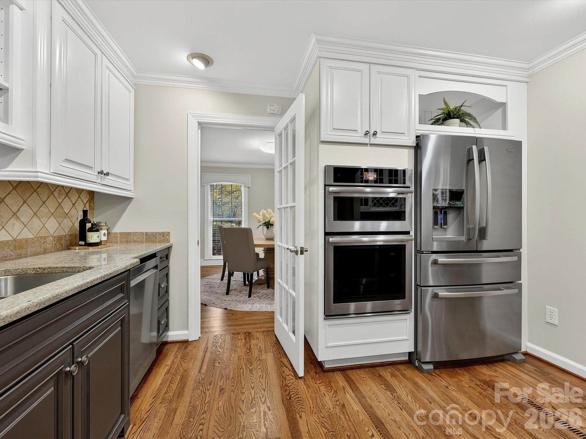 6344 Dovefield Road Charlotte, NC 28277 - Photo 12 of 46 a kitchen with kitchen island wooden floors appliances and cabinets