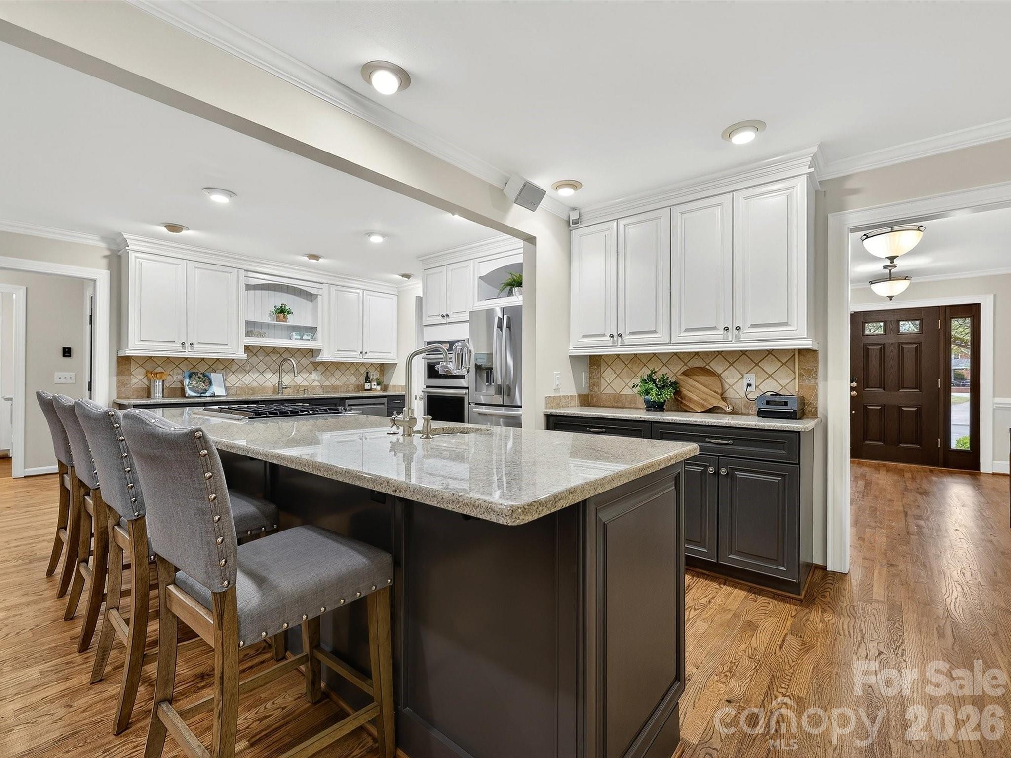 6344 Dovefield Road Charlotte, NC 28277 - Photo 9 of 46 a kitchen with stainless steel appliances granite countertop a table chairs sink refrigerator and cabinets
