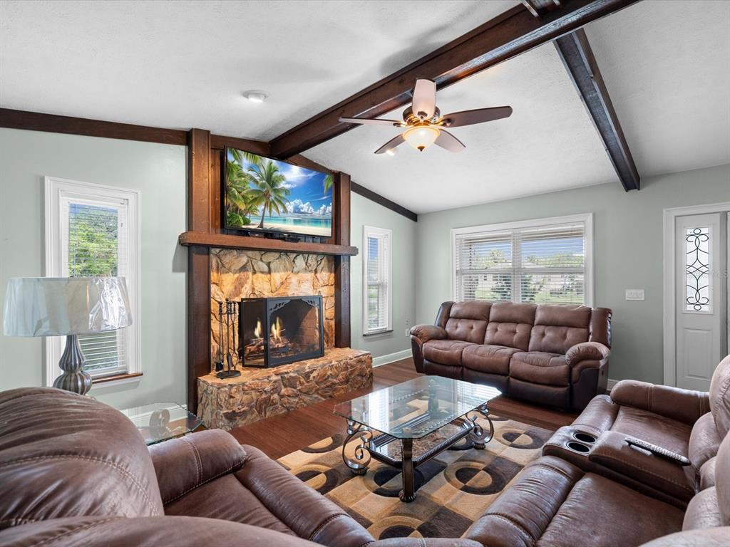 5904 Springrun Court Holiday, FL 34690 - Photo 15 of 53 a living room with furniture a fireplace and a large window