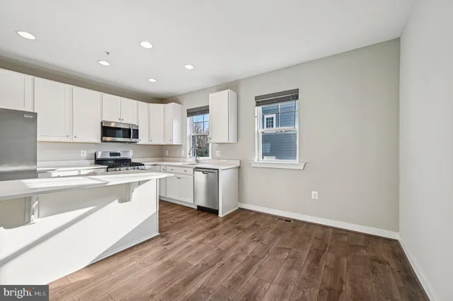 a kitchen with granite countertop a stove a sink and a refrigerator
