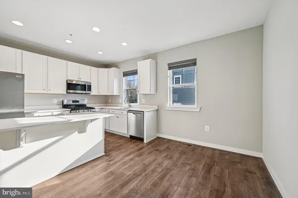 a kitchen with granite countertop a stove a sink and a refrigerator