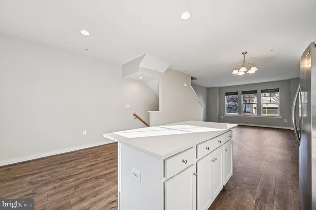 a hall with a sink cabinets and a wooden floor