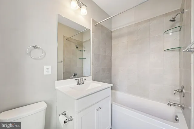 a bathroom with a sink mirror vanity and toilet