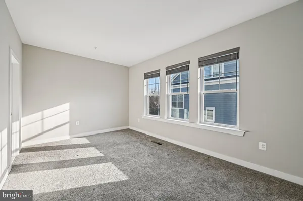 a view of an empty room with wooden floor and closet