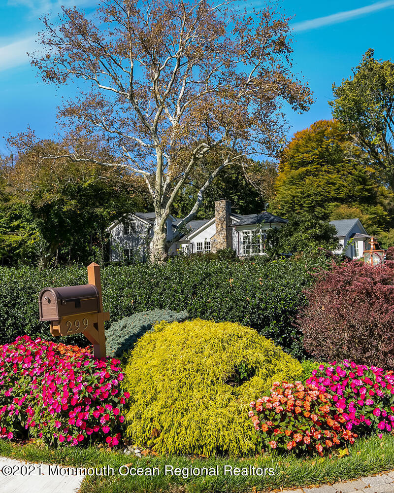 299 Cooper Road Middletown, NJ 07701 - Photo 23 of 27 a view of a garden with flowers and wooden fence